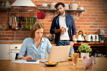 Young couple in savings and home budget concept