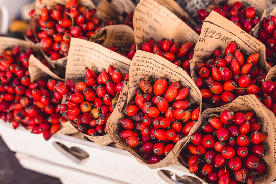 Cornelian cherries as bouquet in the paper with words, in the white, wooden box, autumn decoration