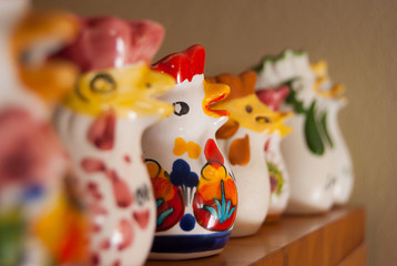 Many hens in glazed earthenware aligned