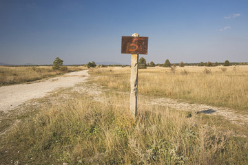 a rusty sign in a lonely field