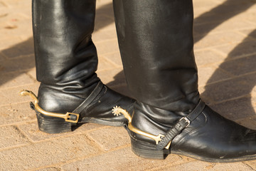 Black high boots for riding with spurs.