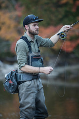 Man fly fishing in the fall in a river