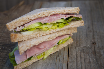 Club Sandwich with Ham and Vegetables. Rustic wooden background.