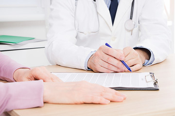 Patient listening intently to a male doctor explaining patient symptoms or asking a question as...