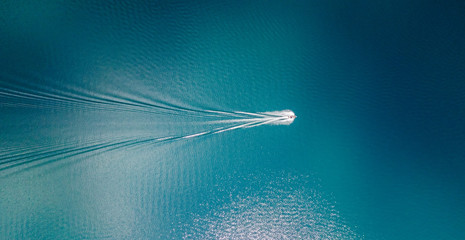 Drone view of a boat sailing across the blue clear waters of lake Tahoe California - obrazy, fototapety, plakaty
