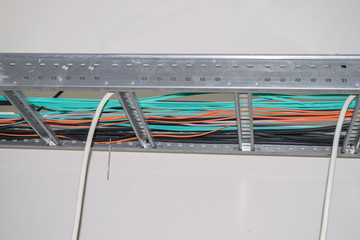 Electrical and fiber optic Internet wires are laid along the metal frame of the suspended ceiling....