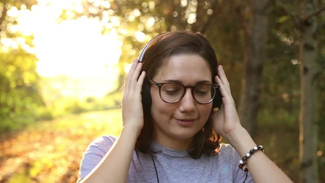 ragazza ascolta musica con le cuffie in un bosco