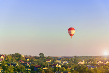  Hot air balloon flying over city on the sunset