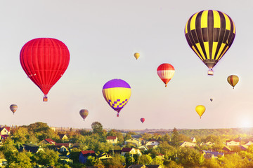 Fototapeta premium Colorful hot air balloons flying over city