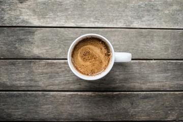 Cup of Coffee with soy milk on a wood table, top view