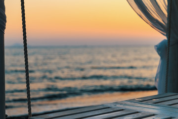 Vue sur la mer depuis un lit à baldaquin sous un coucher de soleil © 4K360