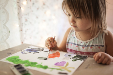 Toddler draw with brush and paint on paper in real