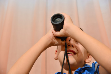 The boy looks in a monocle.