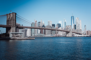 Fototapeta premium Widok na Brooklyn Bridge i Manhattan skyline w świetle wczesnego poranka słońca - centrum Nowego Jorku