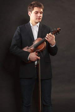 Man man dressed elegantly holding violin