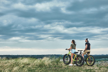 Obraz premium Afternoon sunset with mountainbike couple. Rear view