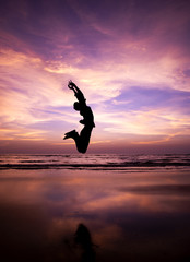 Silhouette of a man Jumping in the air on a beach