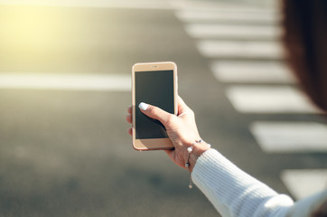 Road city in female hand mobile phone smartphone street crosswalk