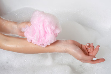 Beautiful woman in bath foam beauty health legs in gand shower sponge care body water