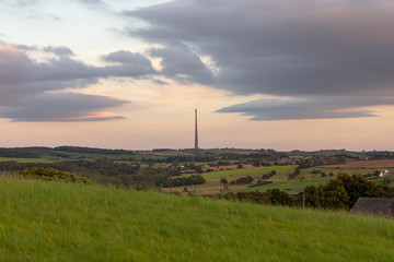 View of the Emley Moor Tower by the light of the setting sun. Rural landscape of England.