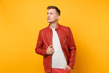 Portrait vogue confident handsome young man 25-30 years in red leather jacket, t-shirt stand isolated on bright trending yellow background. People sincere emotions lifestyle concept. Advertising area.
