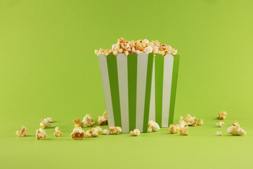 Cinema concept with popcorn in green white bag.