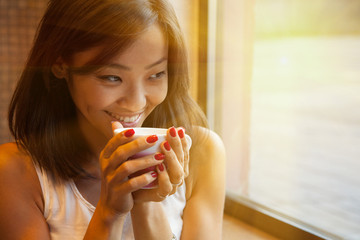 Portrait of an Asian young woman in a coffee shop with a Cup of coffee