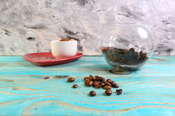 Glass jar with coffee beans on a blue wooden background. Close up of coffee