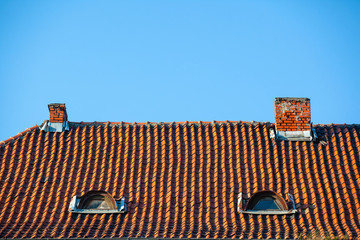 old red tile roof with chimney pipe