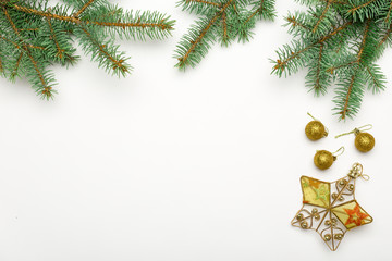 Holiday frame of Christmas decorations on white background with fir branch, gold and red balls, stars. Elegant New Year`s snowy card. Top view. Flat lay.