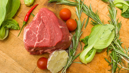 Raw marbled beef with vegetables on a cutting board