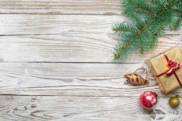 Holiday frame of Christmas decorations on white wood background with fir branch, gold and red...