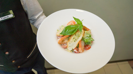 Chef preparing Caesar salad with shrimps