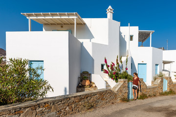 Young woman standing near typical Greek villa with blue doors. Serifos island, Greece © vivoo