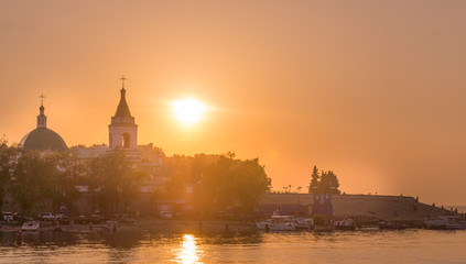 Sunset, the sunset over the Orthodox church on the river Volga
