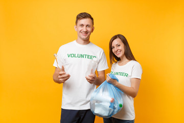 Colleagues couple in t-shirt volunteer trash bag isolated on yellow background. Assistance free help charity grace teamwork. Environmental pollution problem. Stop nature garbage environment protection