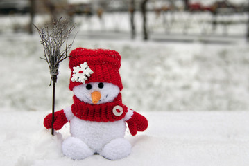 Christmas snowman toy broom on the background of winter nature.