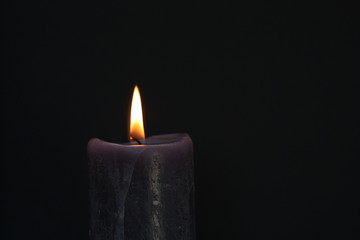 Candle on dark background.