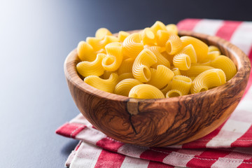 Uncooked elbow macaroni in bowl.