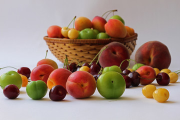 Sepet içerisinde ve beyaz zemin üzerinde çeşitli meyveler 