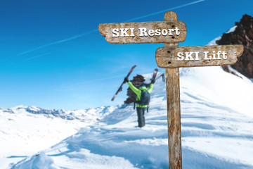 Directions on the signpost to the ski resort and the ski lift.