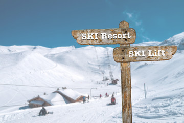 Directions on the signpost to the ski resort and the ski lift.