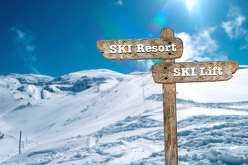 Directions on the signpost to the ski resort and the ski lift.