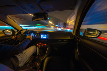 Driving in the night landscape, hands on the wheel. Raindrops.
