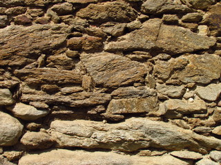 Detail of an old stone wall of a rural building, texture of natural stone, close-up