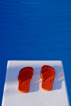 Orange Flip Flops On A Diving Board And Swimming Pool