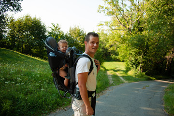 Father on a walk with kik in child carrier backpack