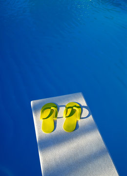 Yellow Flip Flop Sandals On A Swimming Pool Diving Board 