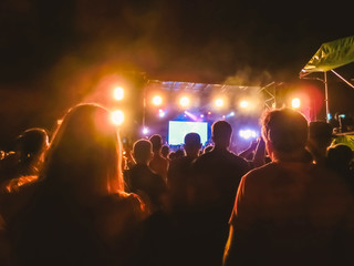 The party, concert concept. Crowd raising their hands and enjoying great rock festival. blur bokeh...