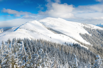 Winter landscape in mountains with snow and blue hills